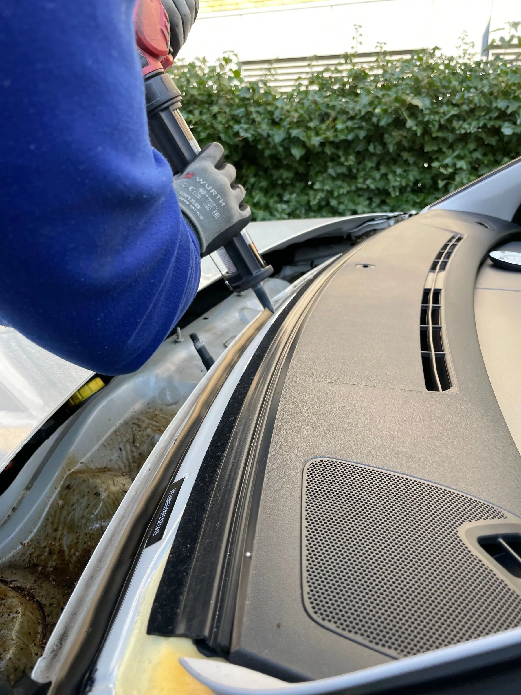 Technician applying urethane adhesive to a windshield